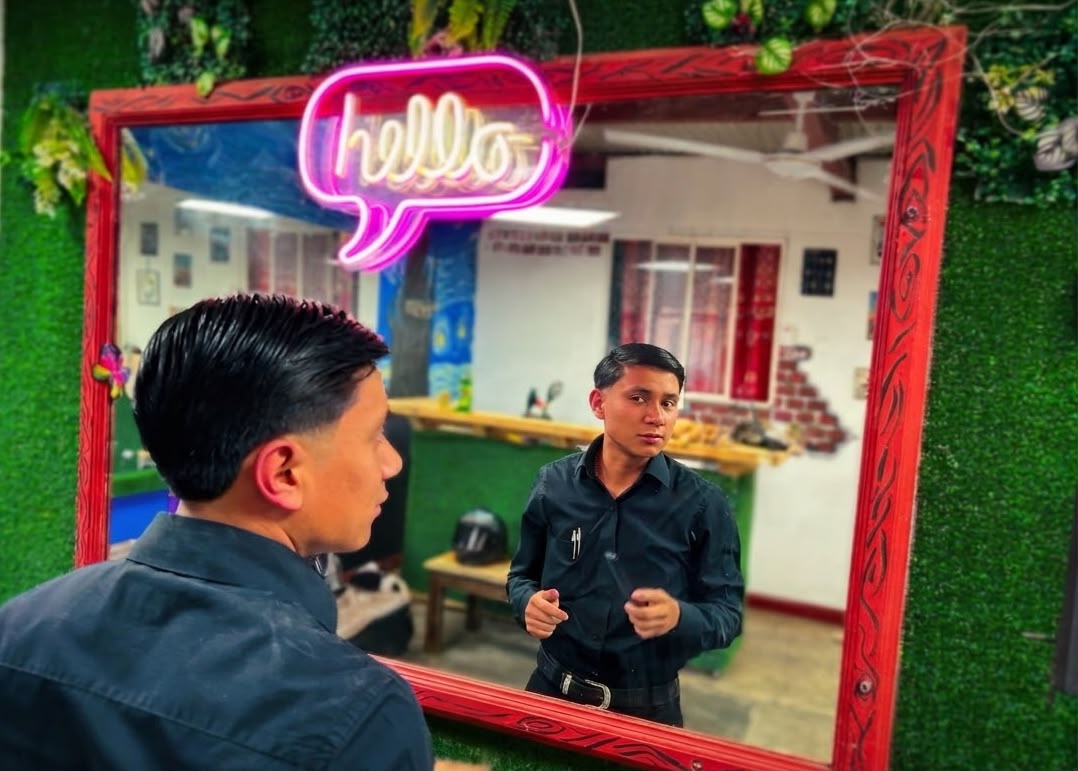 Cliente de Rocky&Chely frente al espejo con el letrero de neón hello