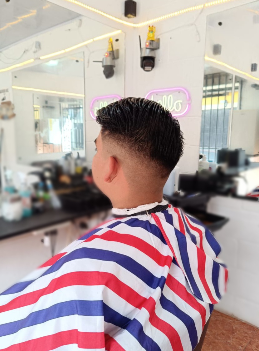 Corte con degradado y cabello peinado hacia arriba realizado en Rocky&Chely