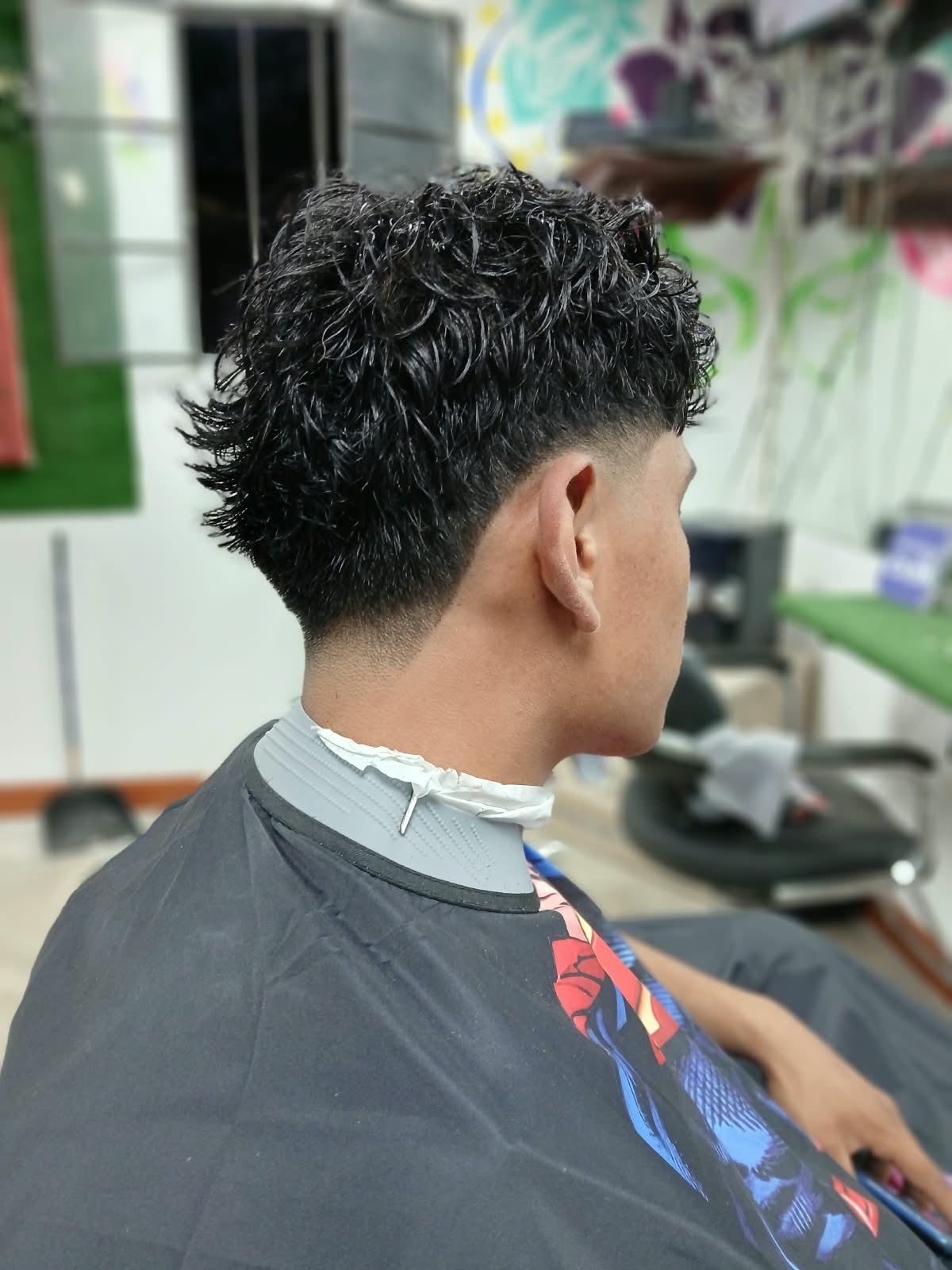 Corte de cabello rizado con degradado realizado en Rocky&Chely
